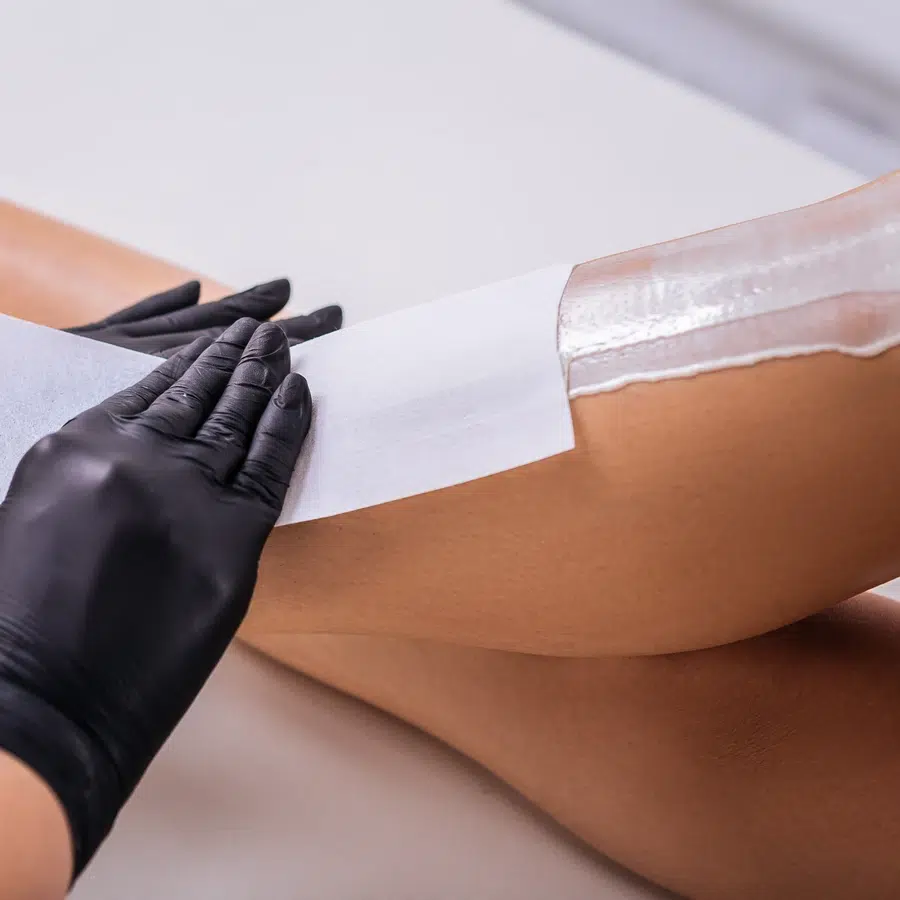 Épilation à la cire sur jambe avec bande